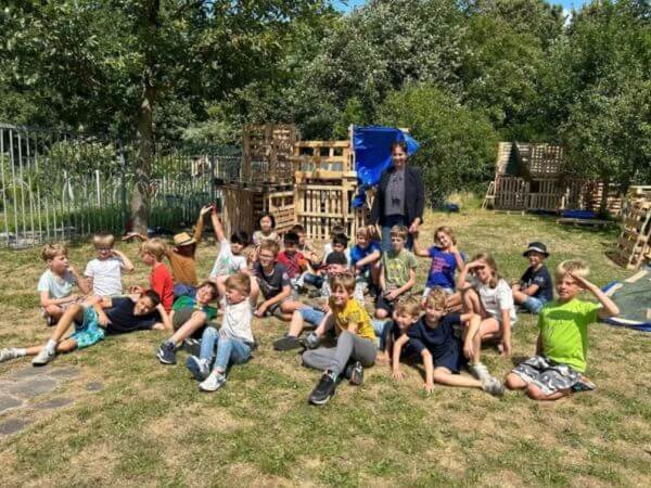 kinderen bij pallets voor huttenbouw